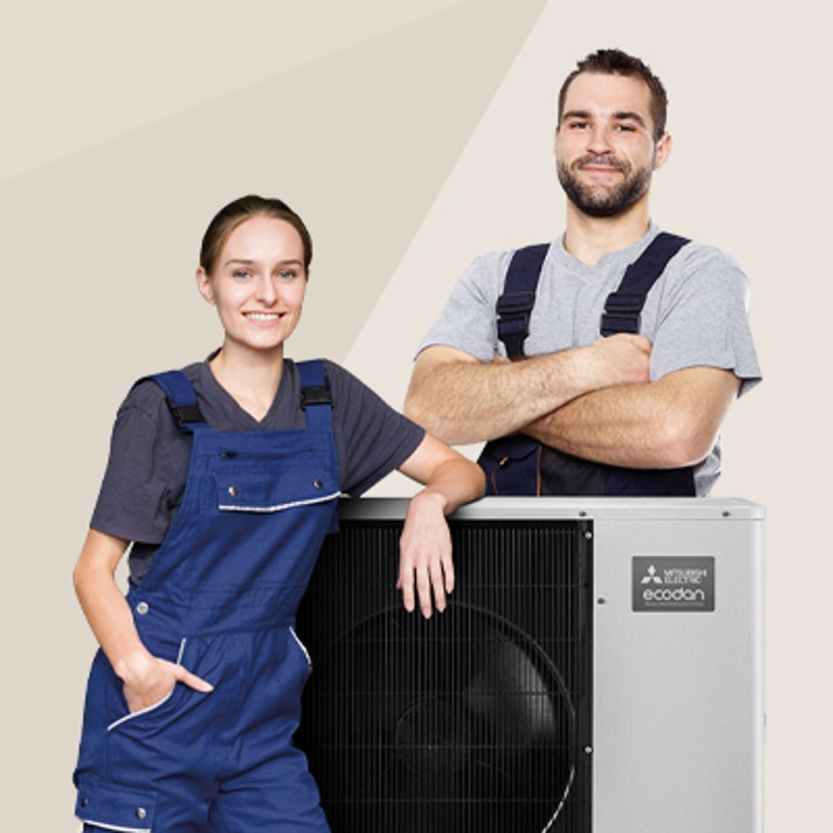 Zwei Fachkräfte in Arbeitskleidung stehen neben einer Mitsubishi Electric Ecodan Außeneinheit
