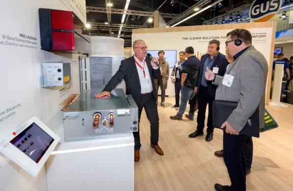 Standführung auf der Chillventa 2024: Eine Person präsentiert an einem Messestand ein technisches Klimasystem vor mehreren Pressevertretern. Im Bild sind Produkte der Mitsubishi Electric M-Serie sowie der eingeblendete Titel „Chillventa 2026 – Standführung für Pressevertreter“ zu sehen.