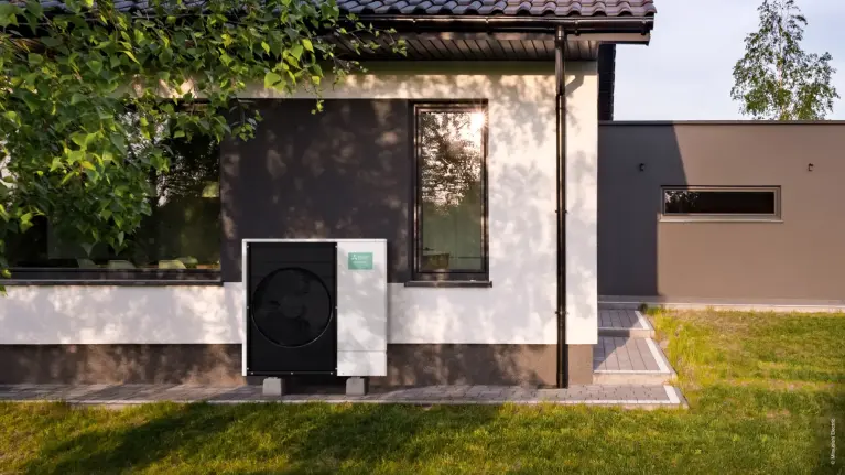 Wärmepumpe an der Hauswand im Garten