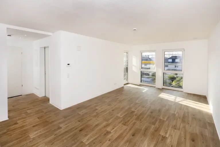 Modernisierter Innenraum einer Wohnung mit Blick auf Balkon und Stadtumgebung