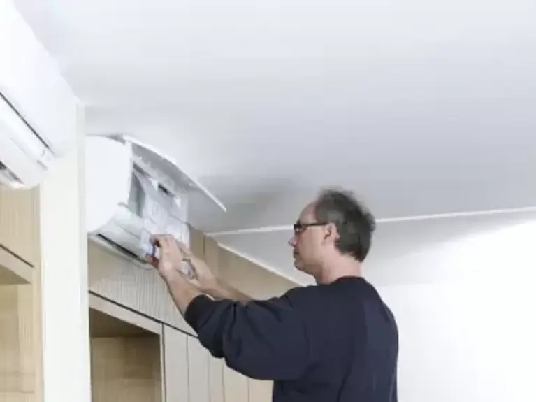 Abbildung Mann wechselt Filter Klimaanlage