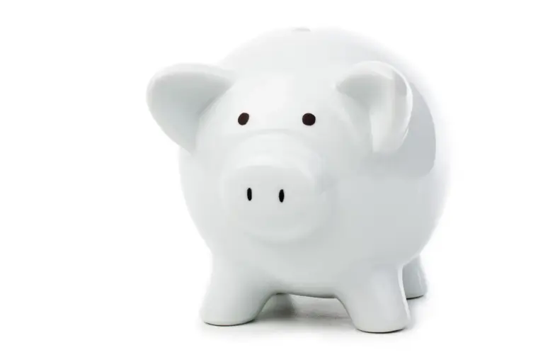 Weißes Sparschwein auf neutralem, hellem Hintergrund als Symbol für Kosteneinsparung.