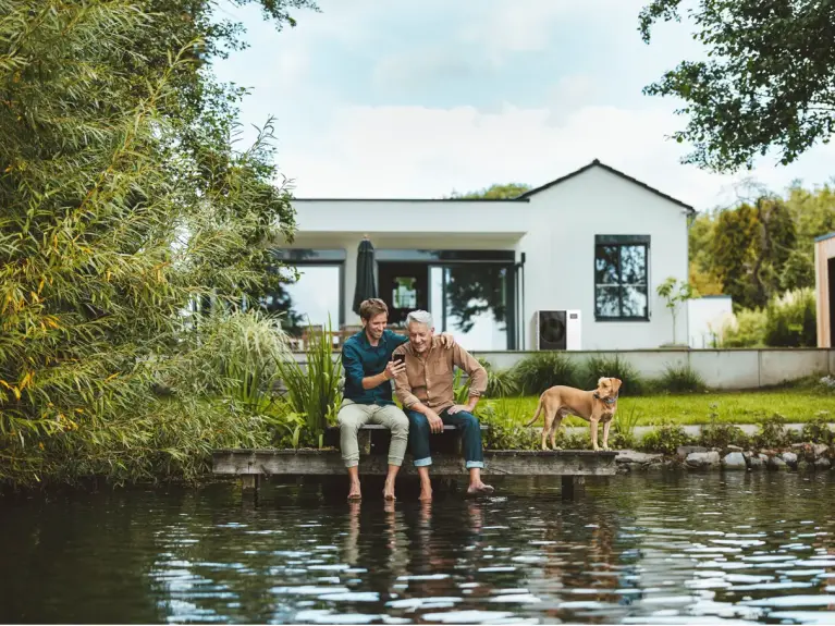 Vater und Sohn auf Steg mit Wärmepumpe im Hintergrund