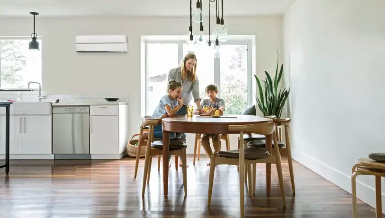 Familie am Esstisch, Klimaanlage im Hintergrund Bild einer Familie am Esstisch, Klimaanlage im Hintergrund