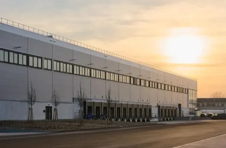Abbildung Logistikhalle von außen bei Sonnenuntergang