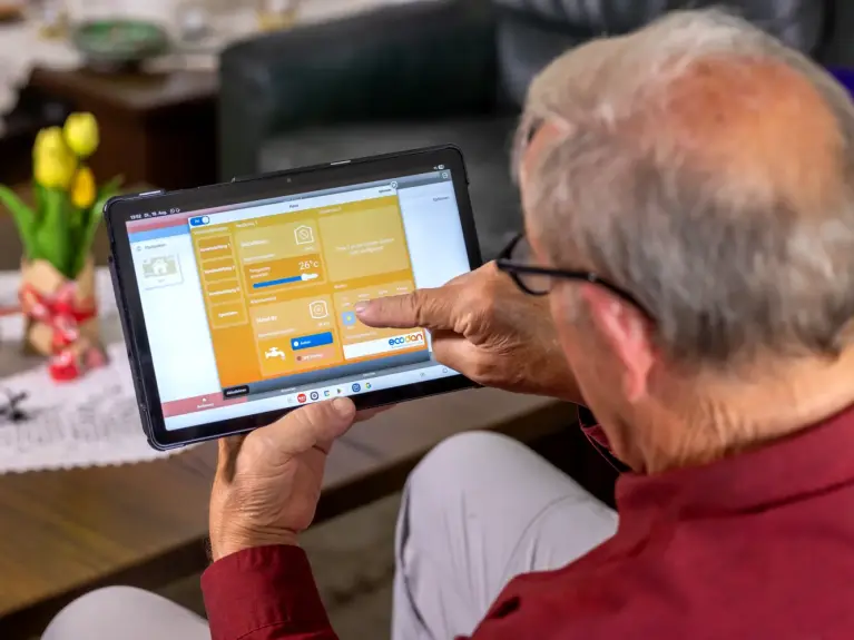 Benutzer steuert Heizsystem per MELCloud App auf dem Tablet