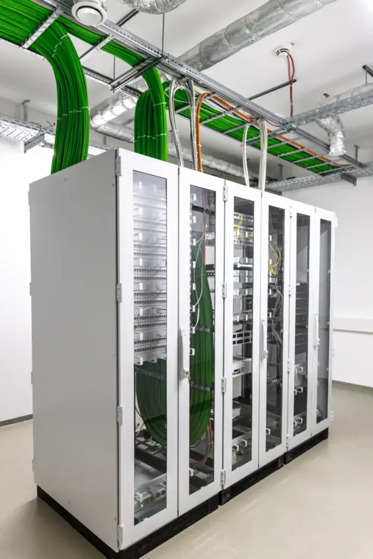 Serverrack mit strukturierten, grünen Netzwerkverkabelungen und Kabeltrassen in modernem Technikraum