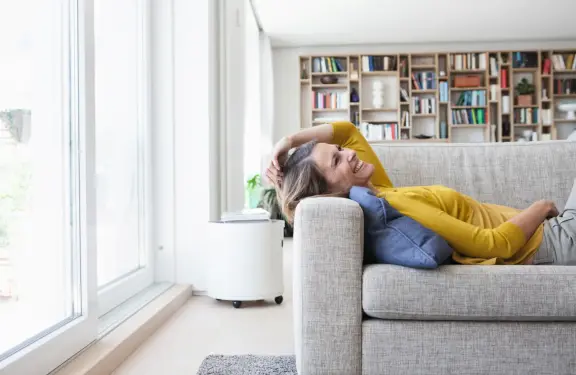 Femme allongée sur un canapé, souriante