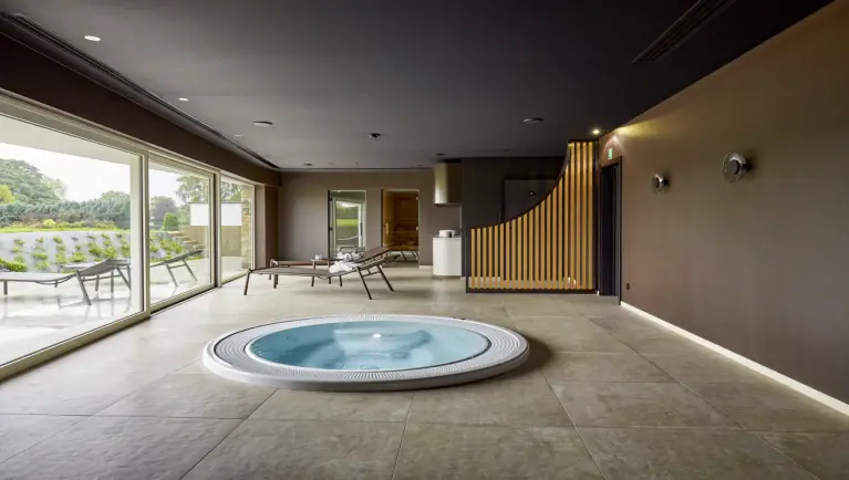 Wellnessruimte met bubbelbad en ligstoelen