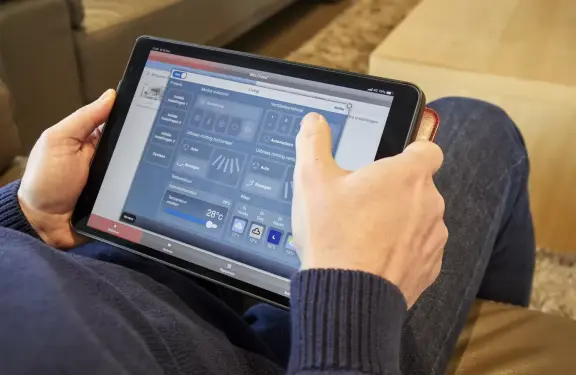 Man bedient airconditioner met centraal besturingssysteem op tablet