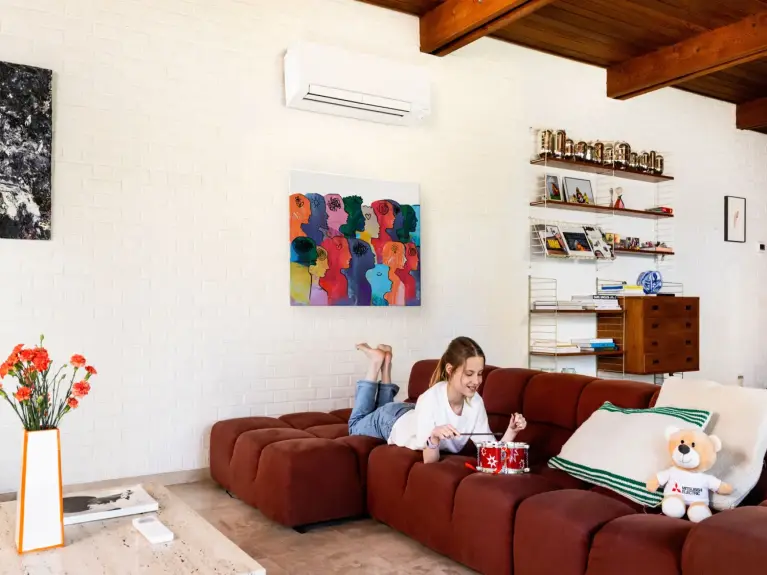 Meisje maakt muziek op haar speelgoedtrommel in de zetel