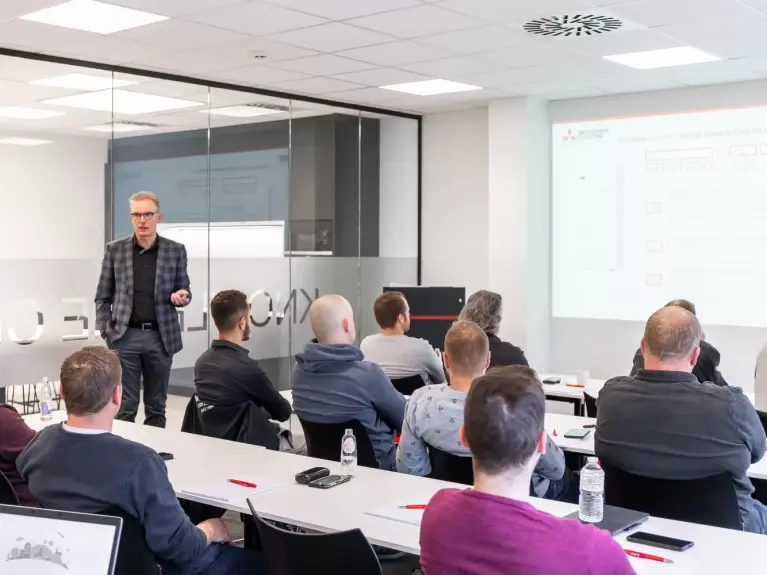 Un professionnel explique à plusieurs installateurs l'utilisation d'un projecteur 