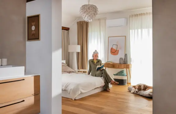 Dame zit op haar bed in haar slaapkamer