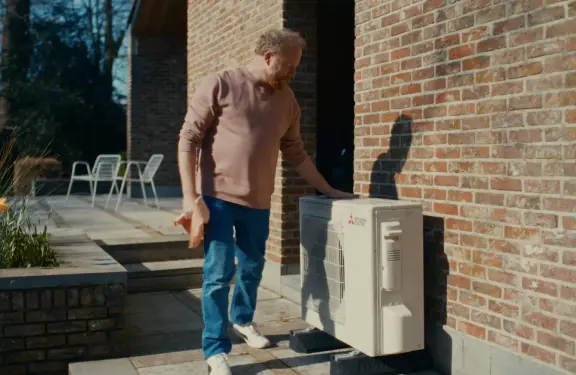 Un homme nettoie son unité extérieure