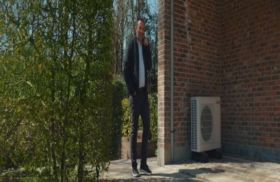 L'homme est au téléphone et passe devant l'unité extérieure. L'homme est au téléphone et passe devant l'unité extérieure.